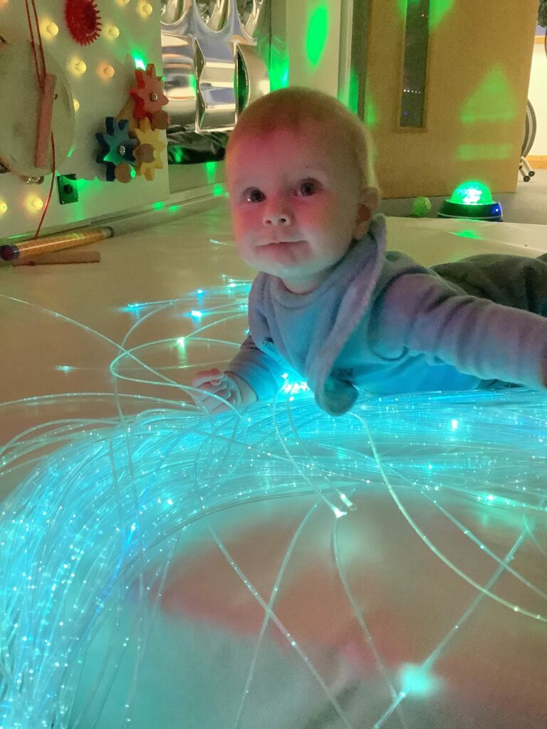 Sensory development of baby laid on tummy surrounded by fibre optic lights